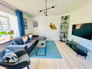 a living room with a couch and a flat screen tv at aday - Modern 1 Bedroom Charming Central Apartment with Public Parking in Aalborg