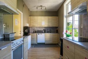 uma cozinha com armários de madeira e um frigorífico branco em Nicolai B&B em Lidköping