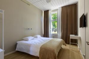 1 dormitorio con cama blanca y ventana en Nicolai B&B, en Lidköping