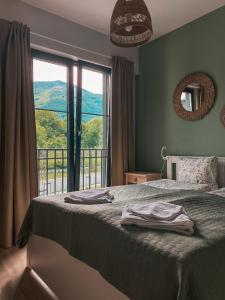 a bedroom with a bed and a window with a view at Vitosha View Apartment & Free Parking in Sofia