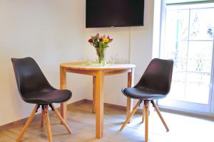 a table with two chairs and a vase of flowers at Hopkas Remise in Lehde