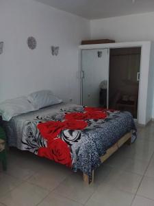 a bedroom with a bed with red roses on it at Appart-hotel Veras Samana No14 in Santa Bárbara de Samaná