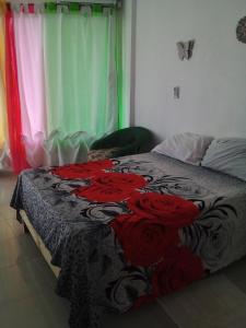 a bedroom with a bed with red roses on it at Appart-hotel Veras Samana No14 in Santa Bárbara de Samaná