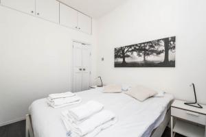 um quarto branco com uma cama com toalhas em Fantastic 1BD flat in the centre em Londres
