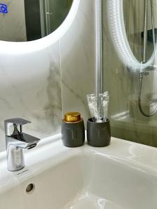 umywalkę w łazience z 2 świecami i lustrem w obiekcie Talan life aparts w mieście Atyrau