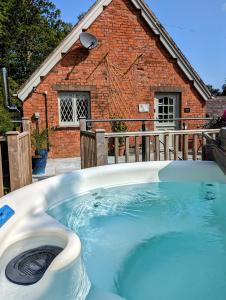 a large hot tub in front of a house at The Coach House Apartment at Cefn Tilla Court, Usk in Usk
