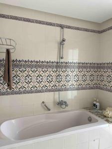 a white bath tub in a tiled bathroom at Villa avec piscine privée in Tabarka