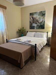 a bedroom with a bed with a painting on the wall at Gavrilis Apartments in Nénita