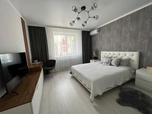 een slaapkamer met een bed en een televisie. bij Comfort Apartment in Vinnytsya
