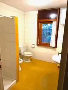 ein Bad mit einem WC, einem Waschbecken und einem Fenster in der Unterkunft Villa Il Platano con giardino Beachfront in Forte dei Marmi