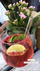 uma bebida num copo ao lado de um vaso com flores em Keller´s Ferienwohnung an der Saale em Schwarzenbach an der Saale