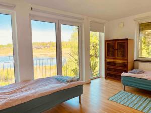 a bedroom with a bed and a balcony with windows at Bjurviks Villa - Flat 1 in Flen
