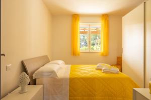 1 dormitorio con 1 cama y una ventana con cortinas amarillas en COLOR DREAM RESIDENCE Case Vacanza Monopoli, en Monopoli