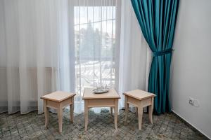 stół i dwa krzesła przed oknem w obiekcie Hotel Rin w Sybinie