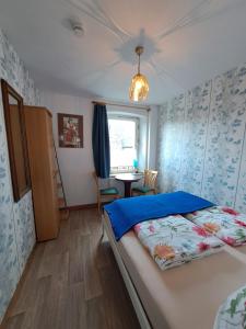 Un dormitorio con una cama y una mesa. en Keller´s Ferienwohnung an der Saale, en Schwarzenbach an der Saale