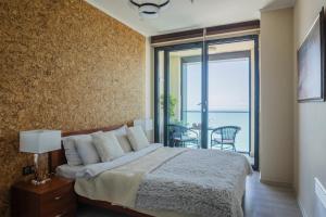 a bedroom with a bed and a view of the ocean at Porta Batumi Tower Sea breeze 2012 in Batumi