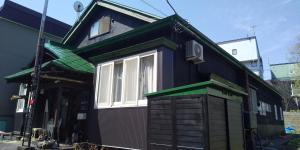 uma casa preta com um telhado verde e uma janela em Minpaku Ota - Vacation STAY 11959 em Otaru