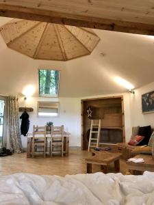 a living room with a bed and a table and chairs at Woodpecker Cabin with Hot tub in King's Lynn