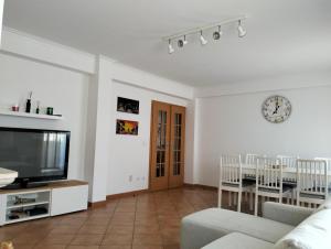 - un salon avec un canapé, une télévision et une table dans l'établissement Casa de Peniche, à Peniche