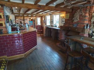 a bar in a restaurant with a brick wall at The Horse and Cart in Peasmarsh