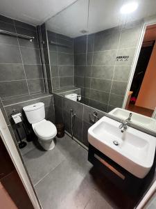 een badkamer met een wit toilet en een wastafel bij Cosy Suites in Kuala Lumpur