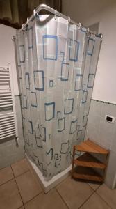 a shower curtain in a bathroom with a wooden stool at ACasaMiaSanPietro in Rome