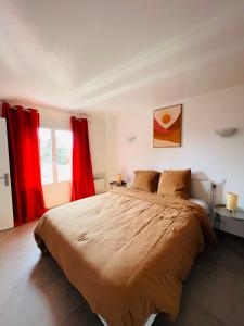 a bedroom with a large bed with red curtains at Villa Les Mimosas Spa-Jacuzzi in Saint-Raphaël