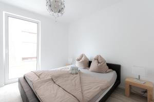 um quarto branco com uma cama com almofadas em LULEX IV - Traumwohnung Terasse Garten in Neuss em Neuss