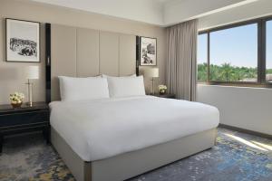 ein großes weißes Bett in einem Zimmer mit Fenstern in der Unterkunft Al Ahsa InterContinental, an IHG Hotel in Al-Hasa