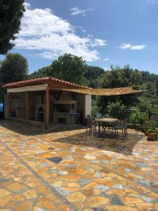 een patio met een tafel en een paviljoen bij Kiparissi Guesthouse in Himare