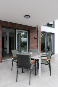 un patio con mesa y sillas y un edificio en LULEX IV - Traumwohnung Terasse Garten in Neuss, en Neuss