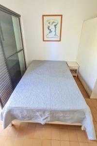 ein großes Bett in einem Zimmer mit Fenster in der Unterkunft Apartamento - Cond. Winbledon - Praia Toninhas in Ubatuba