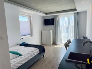 1 dormitorio con cama, escritorio y ventana en BLOMMA Niechorze, en Niechorze