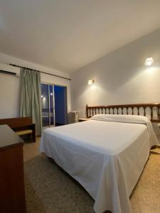 uma grande cama branca num quarto com uma janela em Hostal Blayet em Valência