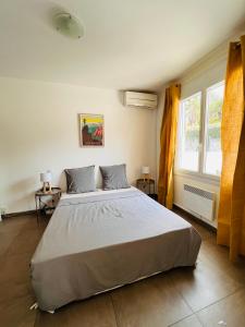 a bedroom with a large bed and a window at Villa Les Mimosas Spa-Jacuzzi in Saint-Raphaël