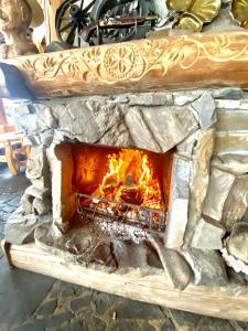 kamienny piec z ogniem wewnątrz niego w obiekcie ZAJAZD BIAŁCZAŃSKI Dom Wypoczynkowy Restauracja w mieście Białka Tatrzanska