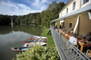 ein Restaurant auf einem Fluss mit Booten im Wasser in der Unterkunft Hotel Obermühle in Görlitz