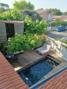 a backyard with a swimming pool and a wooden deck at Maison du bonheur in Lanton