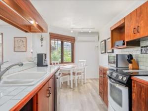 a kitchen with a sink and a stove top oven at Kanaloa at Kona by OUTRIGGER in Kailua-Kona