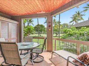 un porche cubierto con mesa y sillas en Kanaloa at Kona by OUTRIGGER en Kailua-Kona