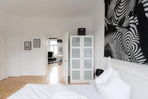 een slaapkamer met een bed en een schilderij aan de muur bij LULEX I - Luxus Apartment Krefeld Alexanderplatz in Krefeld
