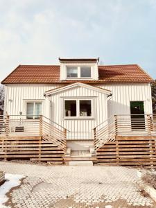 ein großes weißes Haus mit einer großen Veranda und einer Treppe in der Unterkunft Lovely 3-bed Flat In Stockholm in Sollentuna