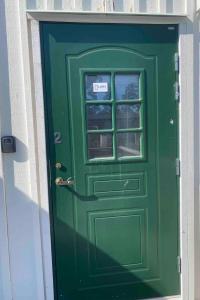 a green door with a sign on it at Lovely 3-bed Flat In Stockholm in Sollentuna