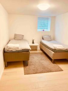 a bedroom with two beds and a window at Lovely 3-bed Flat In Stockholm in Sollentuna