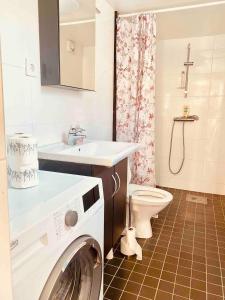 ein Badezimmer mit einer Waschmaschine, einem Waschbecken und einem WC in der Unterkunft Lovely 3-bed Flat In Stockholm in Sollentuna