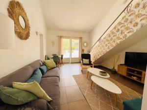 a living room with a couch and a table at Villa Les Mimosas Spa-Jacuzzi in Saint-Raphaël