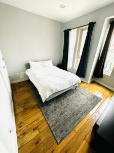 een slaapkamer met een wit bed en een tapijt bij Fishtown Estate ~ Theatre Room ~ Rooftop Terrace in Philadelphia