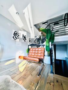 een oranje bank in een woonkamer met een trap bij Fishtown Estate ~ Theatre Room ~ Rooftop Terrace in Philadelphia