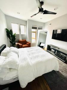 een slaapkamer met een wit bed en een plafondventilator bij Fishtown Estate ~ Theatre Room ~ Rooftop Terrace in Philadelphia