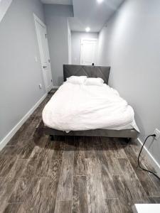 een slaapkamer met een bed en een houten vloer bij Fishtown Estate ~ Theatre Room ~ Rooftop Terrace in Philadelphia